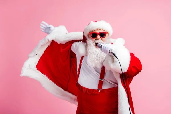 Foto di pazzo grigio barba Babbo Natale x-mas Natale pop star celebrità cantare canzone mic indossare bretelle di occhiali da sole grande berretto pancia copricapo isolato su sfondo color pastello — Foto Stock