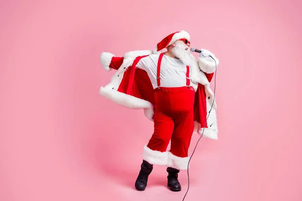 Фотографія на повну довжину божевільна жирна біло-сіра борода Санта Клаус велика живіт пісня мікрофон насолоджуватися Різдвяна вечірка весела вечірка в сонячному склі підвіски чоботи ізольовані пастельний кольоровий фон — стокове фото