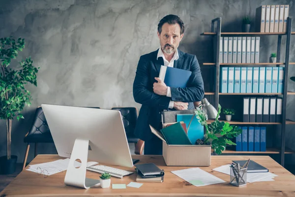 Foto av sparkad ledsen arbetstagare ålder mogen kille mäklare chef förlorat jobb håll kram dagbok dåligt humör pack tillhörigheter personal box monitor skärm dator bord kontor finansiell kris skrivbord inomhus — Stockfoto