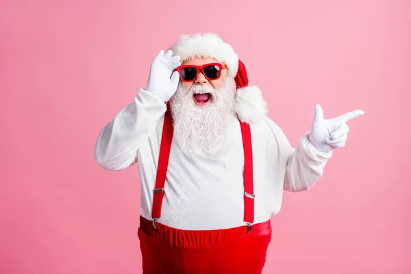Amazed beard fat santa claus enjoy x-mas newyear christmas discount ads point finger touch sunglass wear style stylish trendy headwear suspenders overalls isolated pastel color background