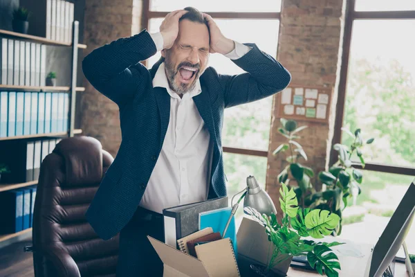 Photo of tired fired crying worker mature guy fail businessman suffer terrible head ache lost job pack belongings box stress scream desperate leave office financial crash desktop indoors — Stock fotografie