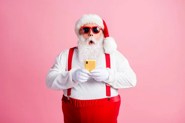 Portrait de son il agréable attrayant homme gras barbu étonné porter costume de Père Noël en utilisant l'appareil blogging post médias sociaux réaction de commentaire multimédia isolé sur fond rose couleur pastel — Photo