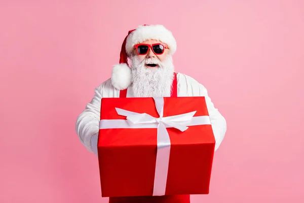 Ritratto del suo bel attraente allegro Babbo Natale che tiene in mano dando maneggevolezza grande scatola regalo congratulazioni saluti Polo Nord isolato su sfondo rosa pastello — Foto Stock