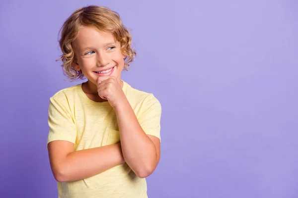 心灵手巧的孩子摸着手指的照片看空旷的空间认为思想穿着黄色的T恤，背景是紫色的 — 图库照片