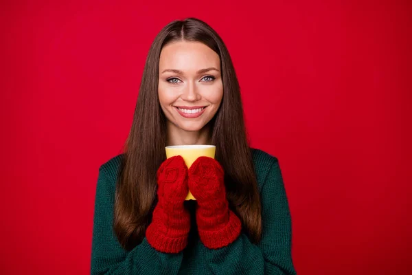 Fotografie pozitivní dívka držet horký šálek kávy ve vlněné rukavice izolované přes jasně červené barvy pozadí — Stock fotografie