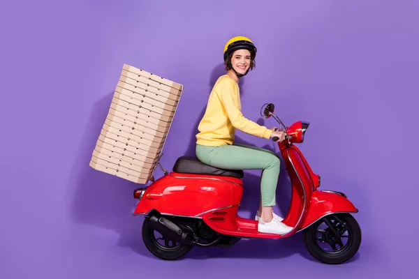 Full body profiel zijkant foto van koerier meisje rijden scooter leveren pizza taart geïsoleerd over violet kleur achtergrond — Stockfoto