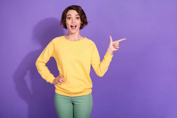 Zdjęcie szokujące dziewczyna punkt wskazujący palec puste miejsce nosić żółty pullover zielony pullover izolowane na fioletowy kolor tła — Zdjęcie stockowe