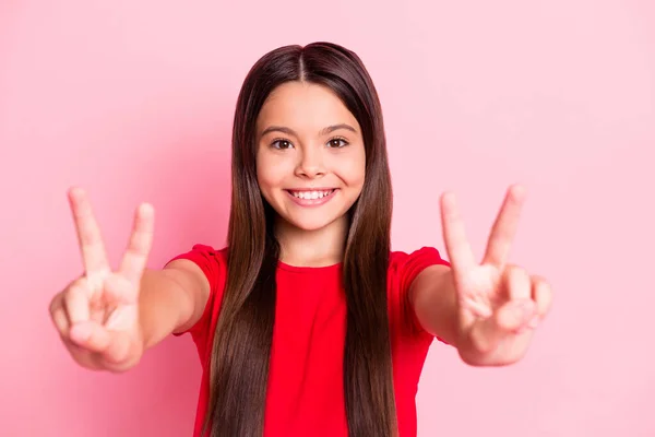Foto de niña latina encantadora hacer v-signo de desgaste camiseta roja aislada sobre fondo de color rosa —  Fotos de Stock