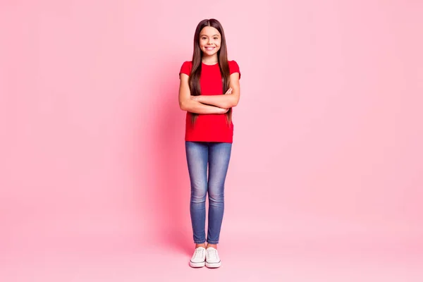 Foto de tamaño de cuerpo completo de lindo dulce pequeña dama largo peinado cruzó las manos confiado auto-seguro sonrisa radiante desgaste casual camiseta roja jeans zapatillas aisladas de color rosa fondo — Foto de Stock