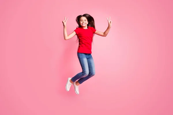 Full size foto di allegro bambino ragazza salto fare v-segno indossare abiti stile casual isolato su sfondo di colore pastello — Foto Stock