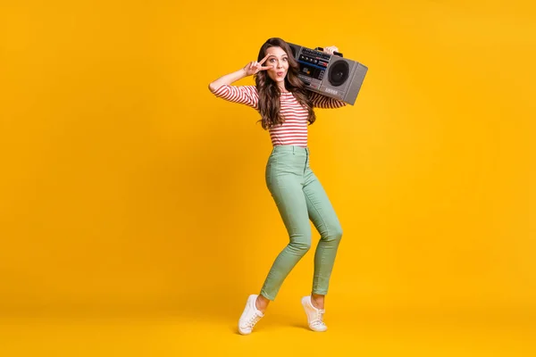 Longitud completa tamaño del cuerpo foto de la niña escuchando boombox retro mostrando v-signo de baile aislado sobre fondo de color amarillo brillante —  Fotos de Stock