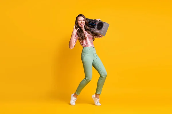 Foto de cuerpo de longitud completa de niña escuchando boombox retro mostrando cuernos letrero de metal pesado aislado en el fondo de color amarillo vibrante —  Fotos de Stock