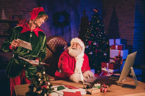 Foto portret van de kerstman en elf kijkend naar elkaar met papieren post — Stockfoto