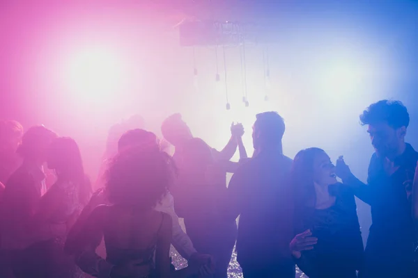 Foto di grande gruppo molte persone affascinante coppia danza flirt neon luminoso rosa faretto moderno club al chiuso — Foto Stock