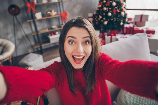 Foto de menina animado fazer selfie sentado no sofá em casa dentro de casa com x-mas Natal ano novo decoração — Fotografia de Stock