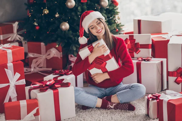 Çekici, neşeli, neşeli, hayalperest kızının portresi halının üstünde oturmuş, el ele tutuşup, evin içinde Noel günü geleneğini kucaklıyor. — Stok fotoğraf