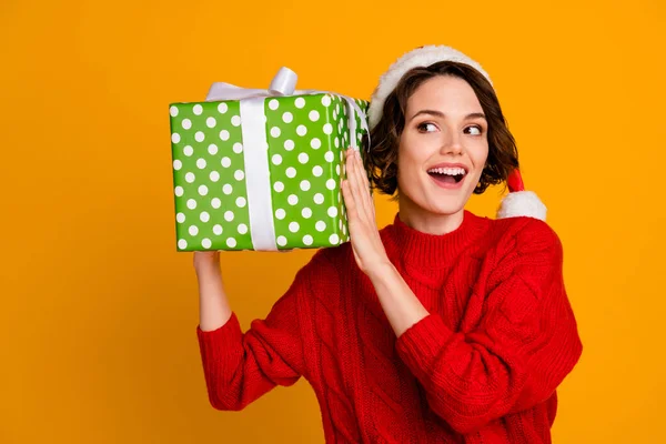Güzel, komik bayanın kış tatillerini kutlarken çekilmiş fotoğrafı büyük bir hediye kutusu içinde Noel Baba şapkası kırmızı örülmüş süveter ve izole edilmiş sarı arka plan olduğunu tahmin ediyorum. — Stok fotoğraf