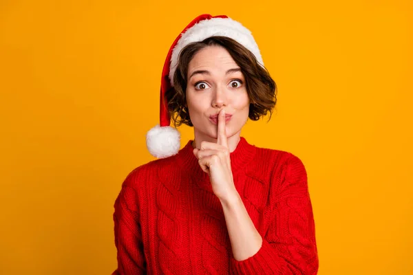 Foto di divertente giocoso signora vacanze invernali è venuto a casa dei genitori senza preavviso x-mas sorpresa tenere il dito sulle labbra indossare cappello di Babbo Natale rosso maglia maglione isolato colore giallo sfondo — Foto Stock