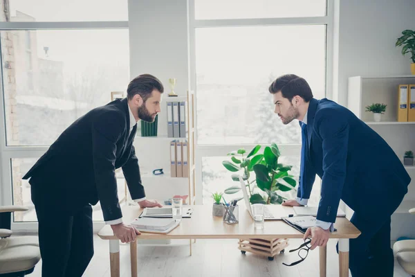 Profile side view portrait of two nice attractive handsome confident serious focused men lawyer attorney competition contest motivation in light white interior workplace workstation