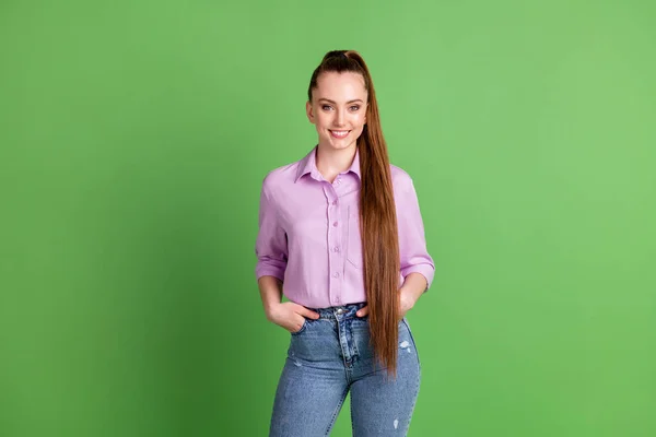 Foto de agradável bonito atraente menina amigável colocar mãos bolsos olhar bom no desgaste da câmera roupas de estilo jovem isolado sobre fundo de cor verde — Fotografia de Stock