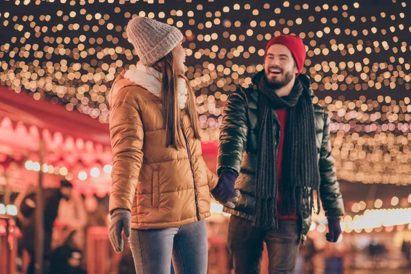 カップルの写真は、アドベンチャー照明の外のクリスマスの夜の下を歩く季節のコートを着用 — ストック写真