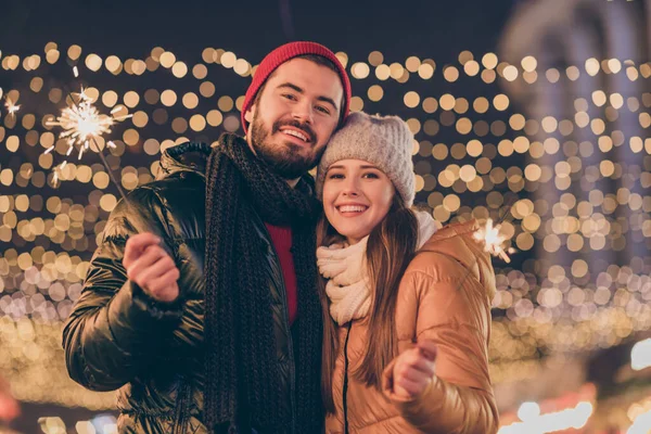 Foto de casal positivo desfrutar comemorar luzes de Natal sparklers sob x-mas tradição fora iluminação desgaste estação casacos — Fotografia de Stock