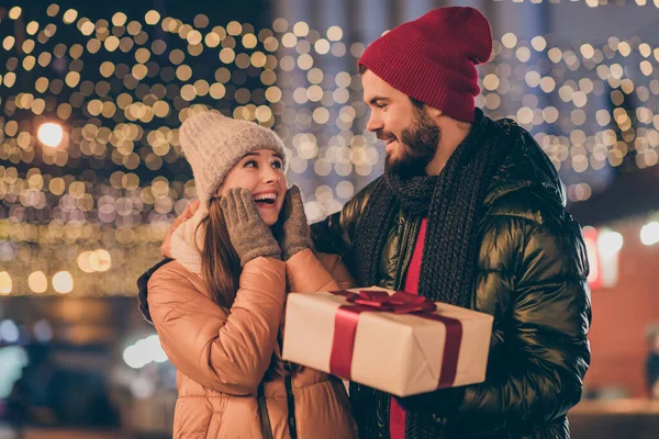 写真の二人の人々驚きの女の子受けますx-masクリスマスプレゼントのボーイフレンド下夜屋外照明シーズンコート — ストック写真