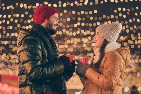 Foto von positivem Paar Mann Frau hält Eierlikör-Becher unter Weihnachtsbeleuchtung — Stockfoto
