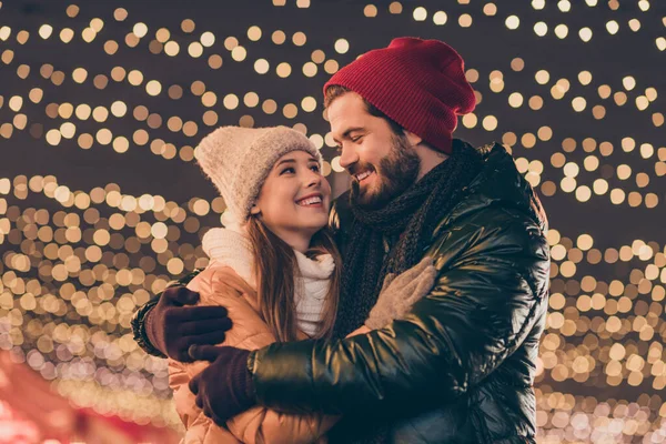 Foto von liebenden Paar Umarmung unter x-mas Abend im Freien Lichter tragen Saison Wintermäntel Kopfbedeckung — Stockfoto