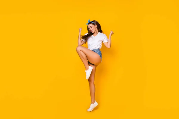 Foto de longitud completa encantado alegre alegre alegre chica disfrutar de descuento lotería ganar salto levantar los puños grito sí usar camiseta blanca azul diadema zapatos aislados de color brillante fondo — Foto de Stock