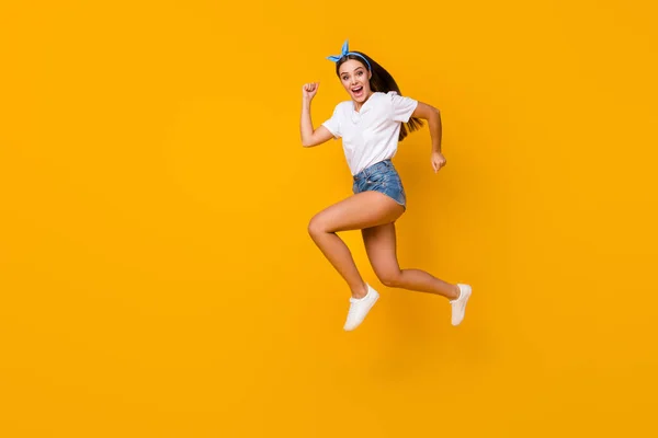 Full size profile side photo cheerful enthusiastic girl jump run after spring free time novelty adverts scream wear white t-shirt shoes blue headband isolated shine bright color background — Stock Photo, Image