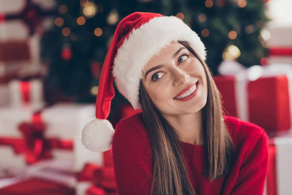 Foto de chica encantadora sonrisa brillante buscar desgaste santa headwear jersey rojo en decorado x-mas sala de estar en el interior — Foto de Stock