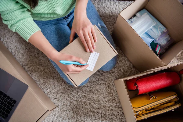 Arriba arriba alto ángulo recortado vista de cerca de su chica gerente de venta freelancer sentado en la alfombra de embalaje orden cosa accesorio distribución industria autónoma dirección de escritura oficina basada en el hogar — Foto de Stock