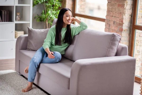 Foto de tamaño completo de contenido agradable chica coreana sentarse cómoda ventana de aspecto diván en casa en el interior — Foto de Stock