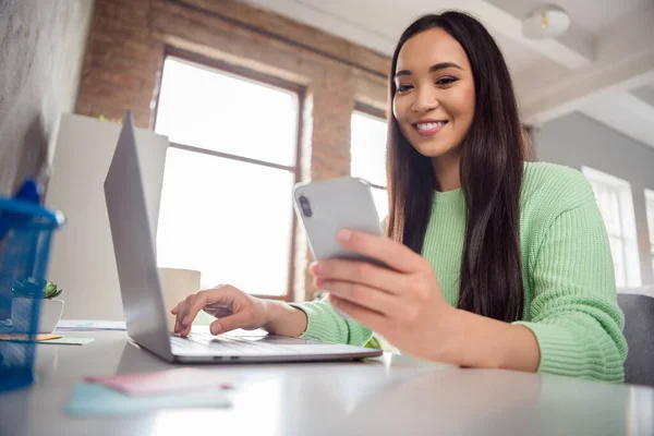 Tienes un mensaje nuevo. Bajo ángulo vista perfil lado foto de gerente inteligente asiática entrenador chica sentarse acogedor mesa trabajo remoto portátil comprobar social media smartphone en casa en el interior —  Fotos de Stock