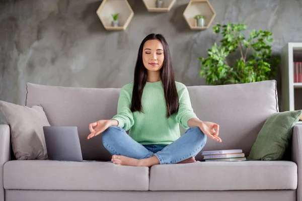 Plná velikost fotografie soustředěný klid korejština dívka sedět gauč nohy přes složené bosá meditovat práce přestávka pauza v domě uvnitř — Stock fotografie