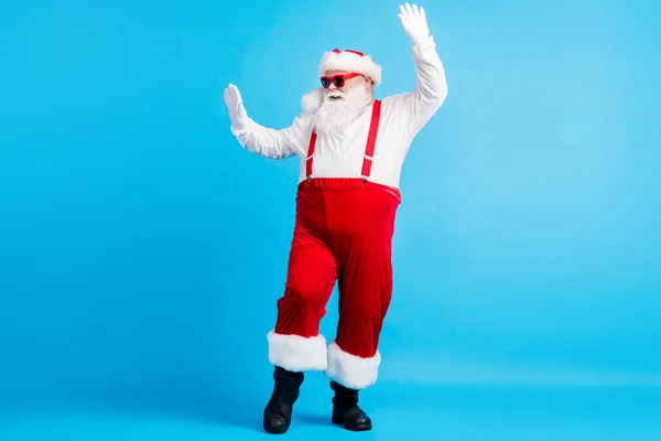 Foto de cuerpo completo de la elegante grasa funky Santa Claus con gran danza de la barba del vientre x-mas navidad nuevo año alegre discoteca usar tirantes monos sunglass aislado color azul fondo — Foto de Stock