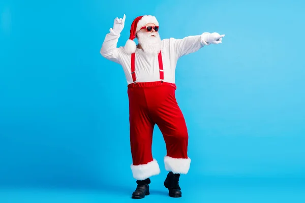 Full size foto di cool hipster Babbo Natale con grande danza pancia x-mas natale discoteca magica indossare bretelle berretto occhiali isolata su sfondo di colore blu — Foto Stock