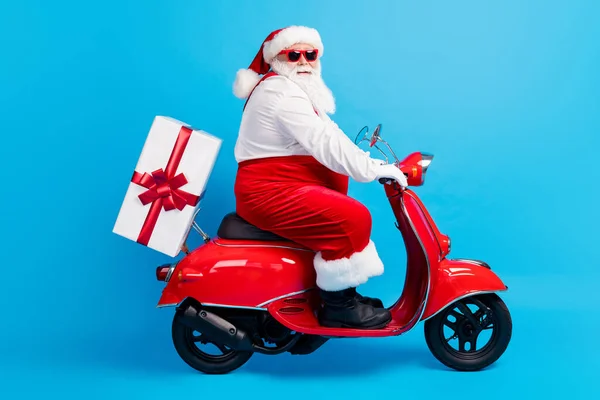 Modern gri sakallı Noel Baba 'nın tam vücut profilli fotoğrafı. Scooter' ı Noel arifesinde teslim et. Hediye paketi giyin. — Stok fotoğraf