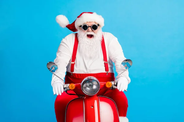 Zdjęcie dziadka szara broda jeździć szybko retro motorower szalony otwarte usta nosić Santa Claus x-mas kostium szelki gogle biały koszula rękawice głowy odizolowany niebieski kolor tło — Zdjęcie stockowe