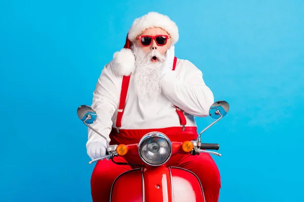 Zdjęcie dziadka szara broda jeździć retro skuter palma kości policzkowe otwarte usta nosić Santa Claus x-mas kostium szelki sunglass biały koszula czapka rękawiczki odizolowany niebieski kolor tło — Zdjęcie stockowe