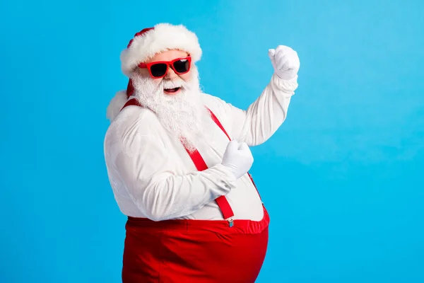 大きな腹ひげを生やしてスタイリッシュな脂肪サンタクラスの写真拳を上げますx-masクリスマス宝くじの着用サスペンダー全体的な青い色の背景に隔離されたサングラス — ストック写真