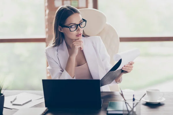 Foto van aantrekkelijke zakenvrouw houd klembord lees collega 's partners contract notebook tabel geconcentreerde gegevens home office sociale afstand formele slijtage specs pak binnen — Stockfoto