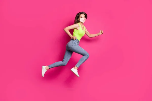Foto lateral de perfil de cuerpo completo de puños de salto de chica positiva con máscara facial naranja aislada sobre fondo de color rosa —  Fotos de Stock