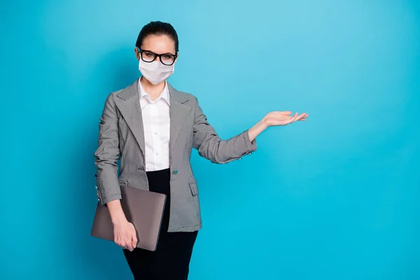 Porträt von trendigen Mädchen Mitarbeiter tragen Laptop hält auf Handfläche kopieren Raum Werbung tragen Maske isoliert blaue Farbe Hintergrund — Stockfoto