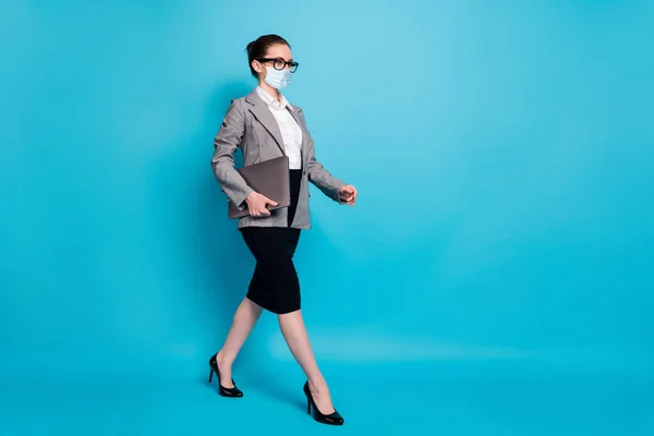 Full length photo of nice content smart lady specialist carrying laptop walking wear mask isolated over bright blue color background — Stock Photo, Image