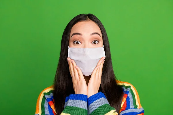 Retrato de las manos muchachas encantadas bastante sorprendidas mejillas utilizar máscara médica facial aislado sobre fondo de color verde — Foto de Stock