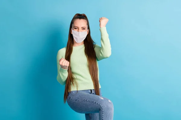 Retrato de menina de cabelos castanhos comemorar infecção covid ganhar desgaste máscara médica isolado fundo de cor azul brilhante — Fotografia de Stock