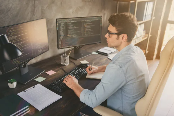 Profile side view portrait of his he nice focused busy experienced smart clever geek guy typing bug track report language at modern industrial interior style concrete wall work place station — Stock Photo, Image