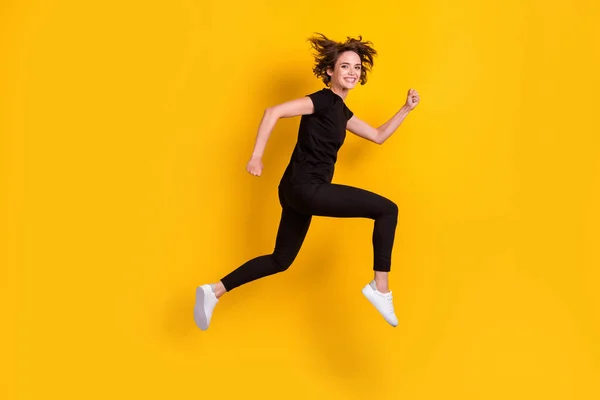 フル長いですボディサイズプロフィール側ビューの美しいです陽気なスレンダーな女の子ジャンプ実行中の高速分離された明るい黄色の背景 — ストック写真